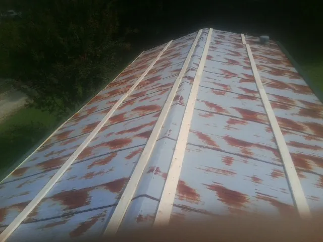Rusted metal roof panels with new wood purlins before replacement — Storm Damage Roof Repair in West Elkton by Roofing Brothers
